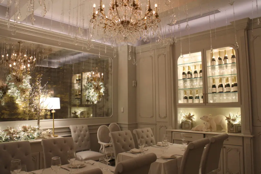 The Cake Bake Shop room with all white interiors and a glitzy chandelier.