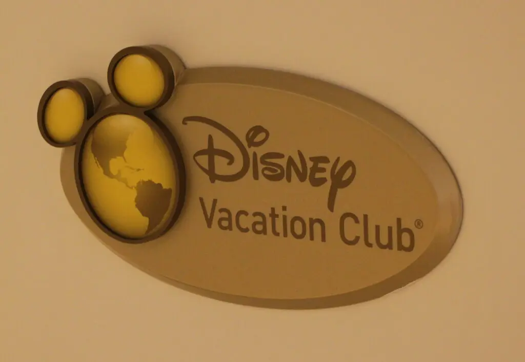 Gold Disney Vacation Club sign with earth with Mickey ears logo.