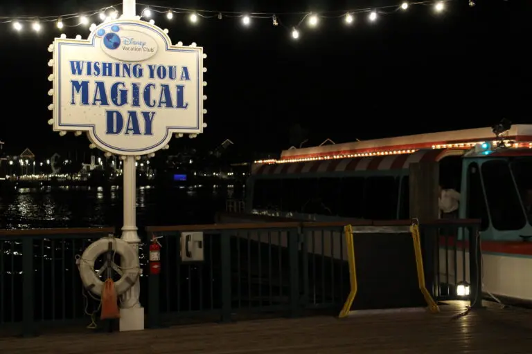 Friendship Boat dock at night with Wishing You a Magical Day sign and string lights.