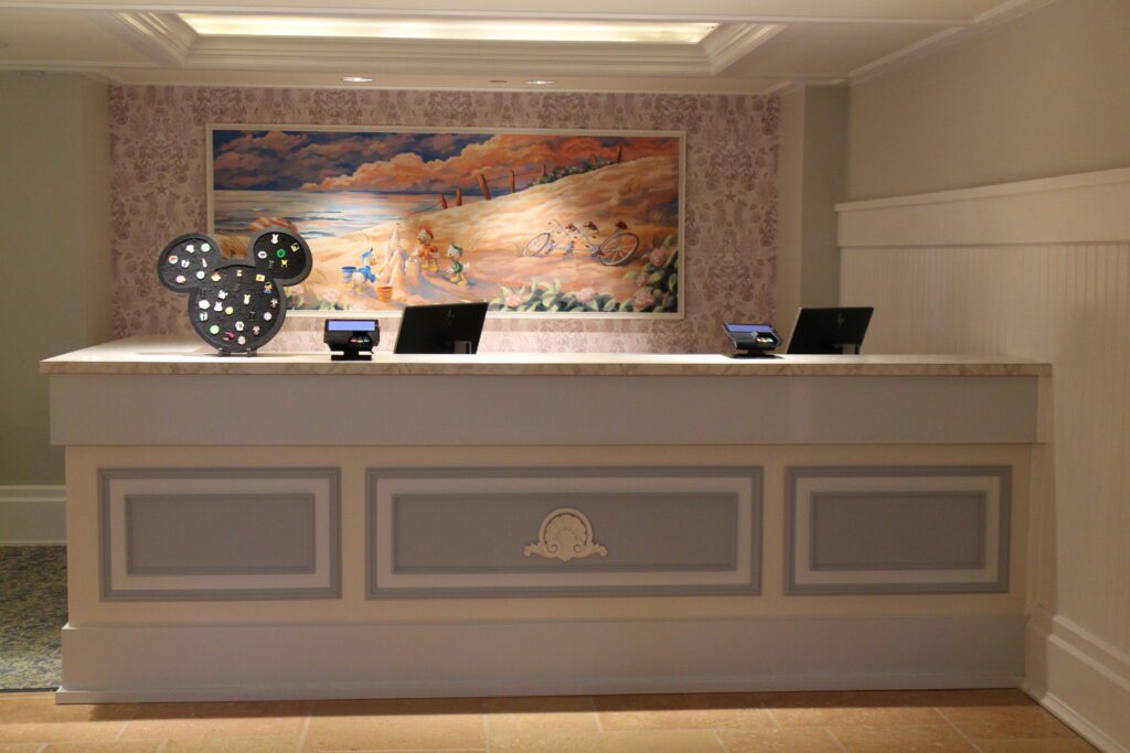 The lobby desk at Beach Club with pastel beach art with Disney characters behind it.It's helpful to know the Disney Vacation Club terms while visiting the front desk.