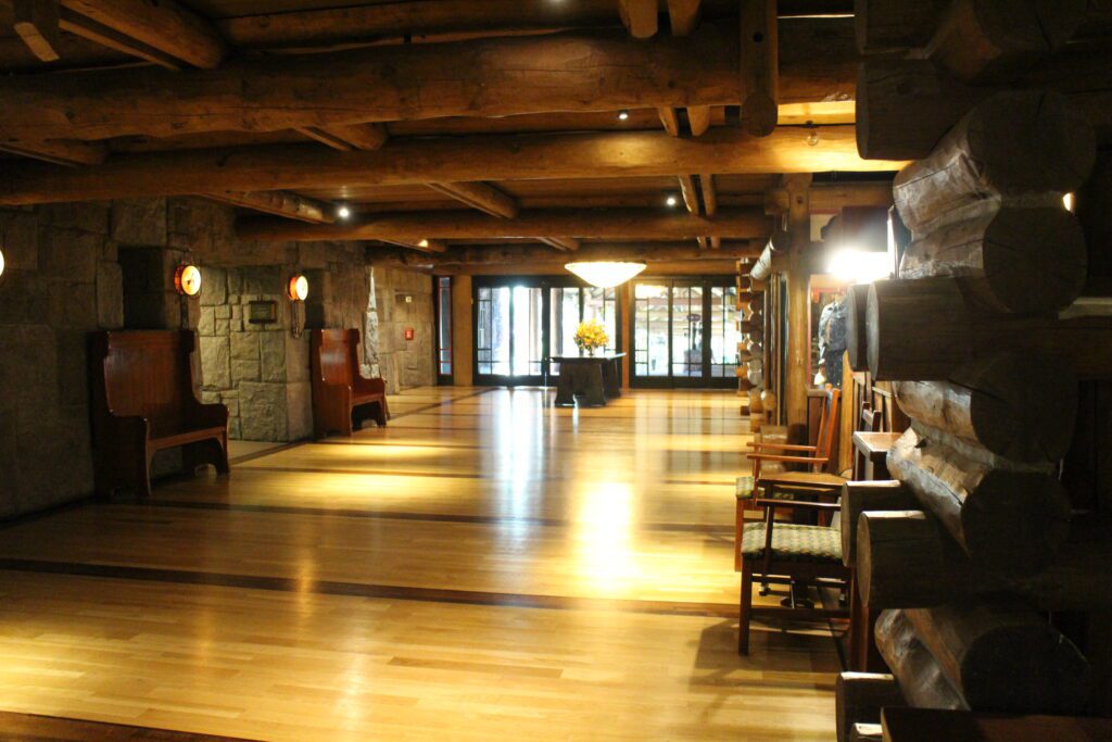 Wilderness Lodge hallway with wood ceilings and floors with sliding glass doors to the outdoors at the end.