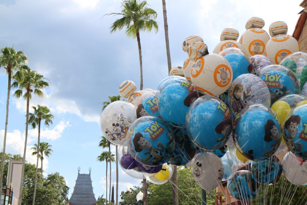 Toy Story, Star Wars and other Disney balloons float in a bunch at Hollywood Studios. The best time to visit Disney World may still include afternoon thunderstorms rolling in, pictured here over the top of the Chinese theater in the background.