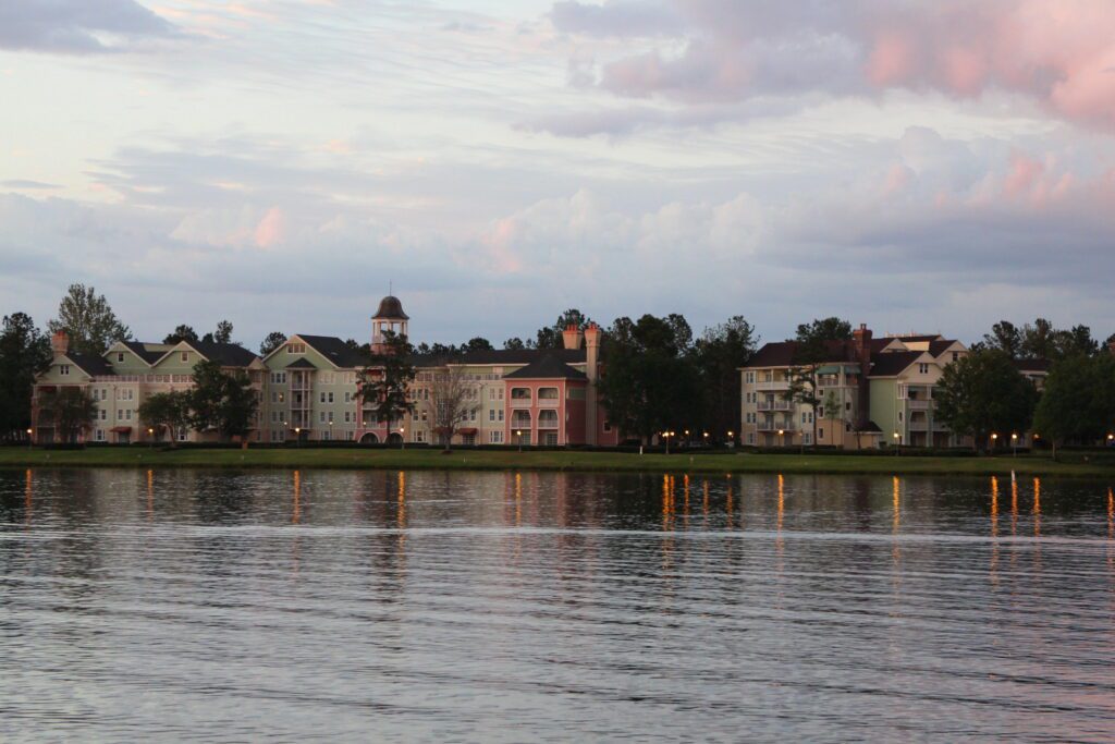 a pastel sky over pastel hotel buildings on a lake