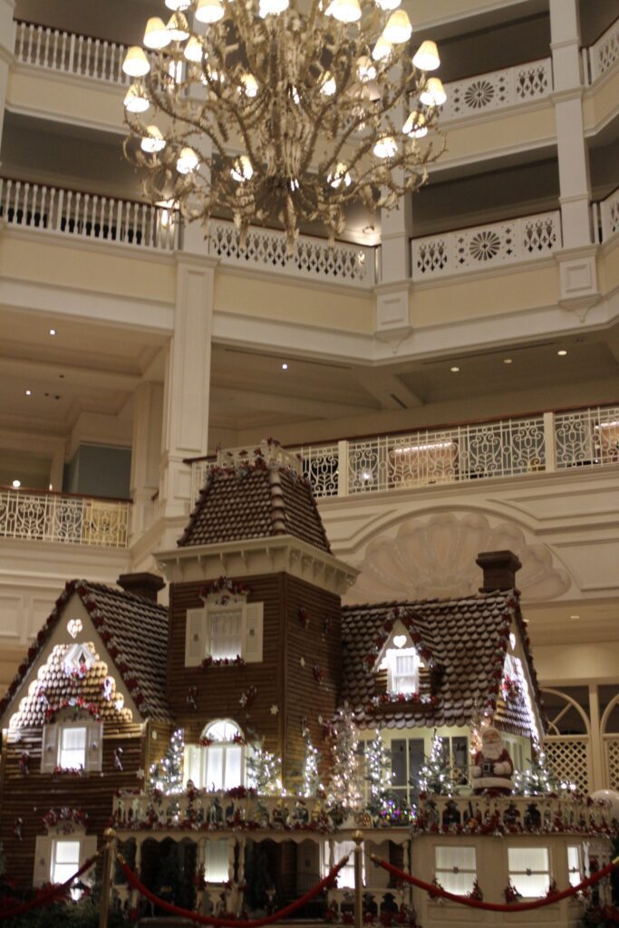 The outside of the Grand Floridian gingerbread house under a vintage white chandelier.