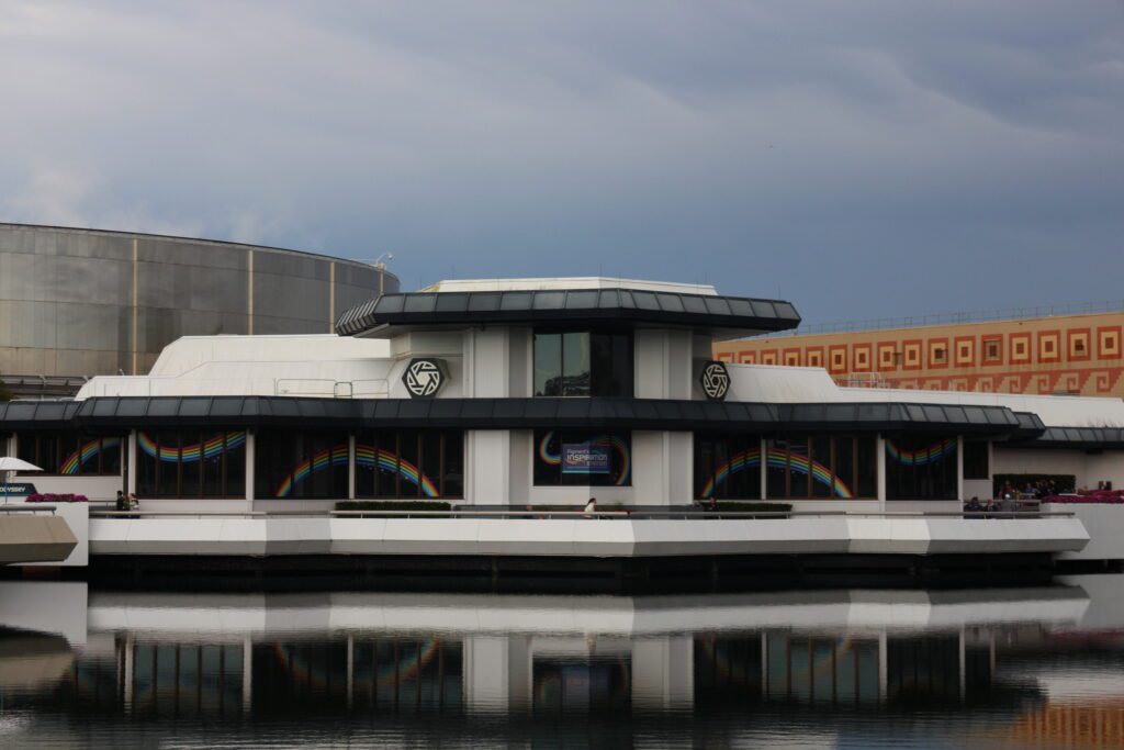 a photo of a black and white building in front of water that says Figment's Inspiration Station