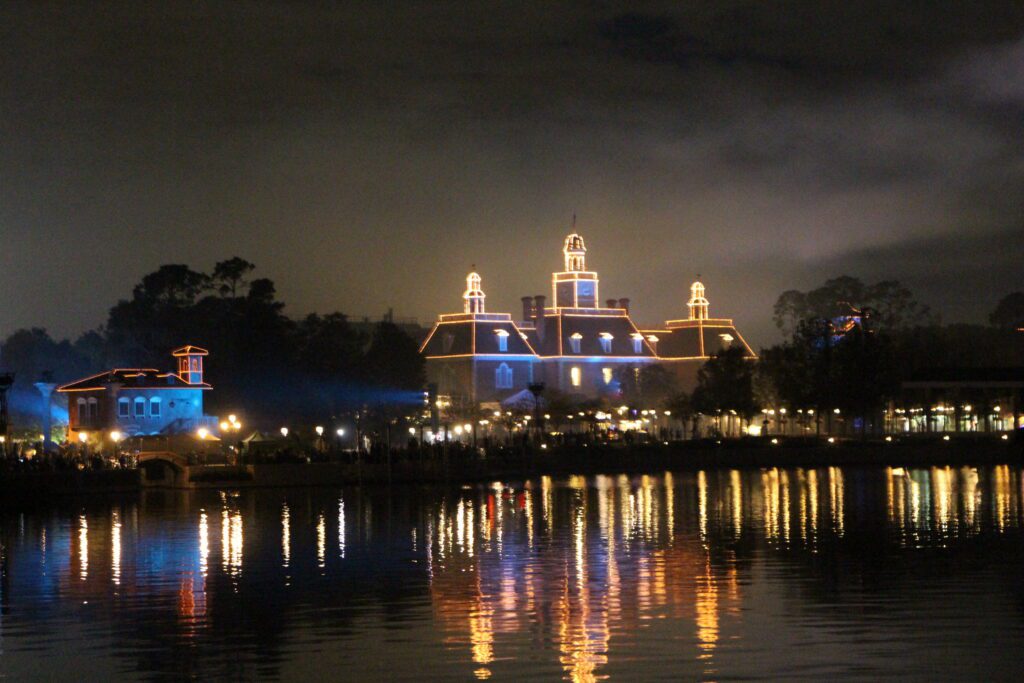 America pavilion lit up with lights lining the building at night in Epcot during the Luminous fireworks show