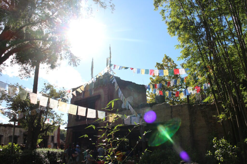 A sun burst over buildings and nature in Disney's Animal Kingdom.