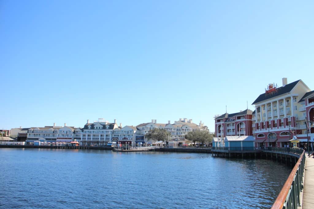 Colorful, multi-story Disney BoardWalk buildings surround a lake.