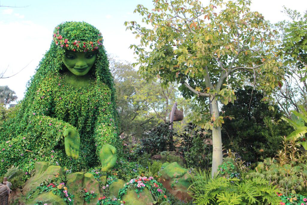 A topiary of the Te Fiti character from Moana surrounded by greenery.