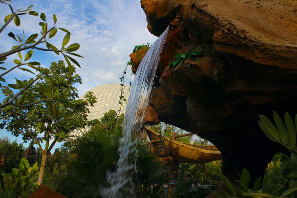 Moana attraction with a waterfall and Spaceship Earth in the background.