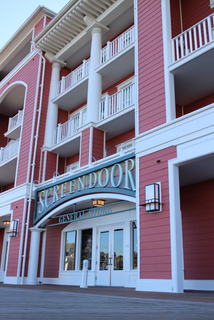 A red outdoor store front of the DVC store Screen Door General Store at Disney's BoardWalk Villas where guests can find groceries and merchandise.