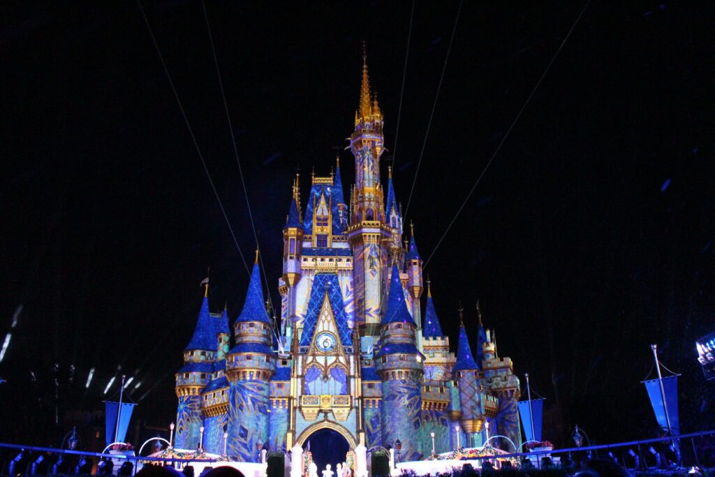 Cinderella Castle at Magic Kingdom at night with a Frozen fractal snowflake inspired overlay during the Frozen Holiday Surprise stage show at Mickey's Very Merry Christmas Party at Disney World.