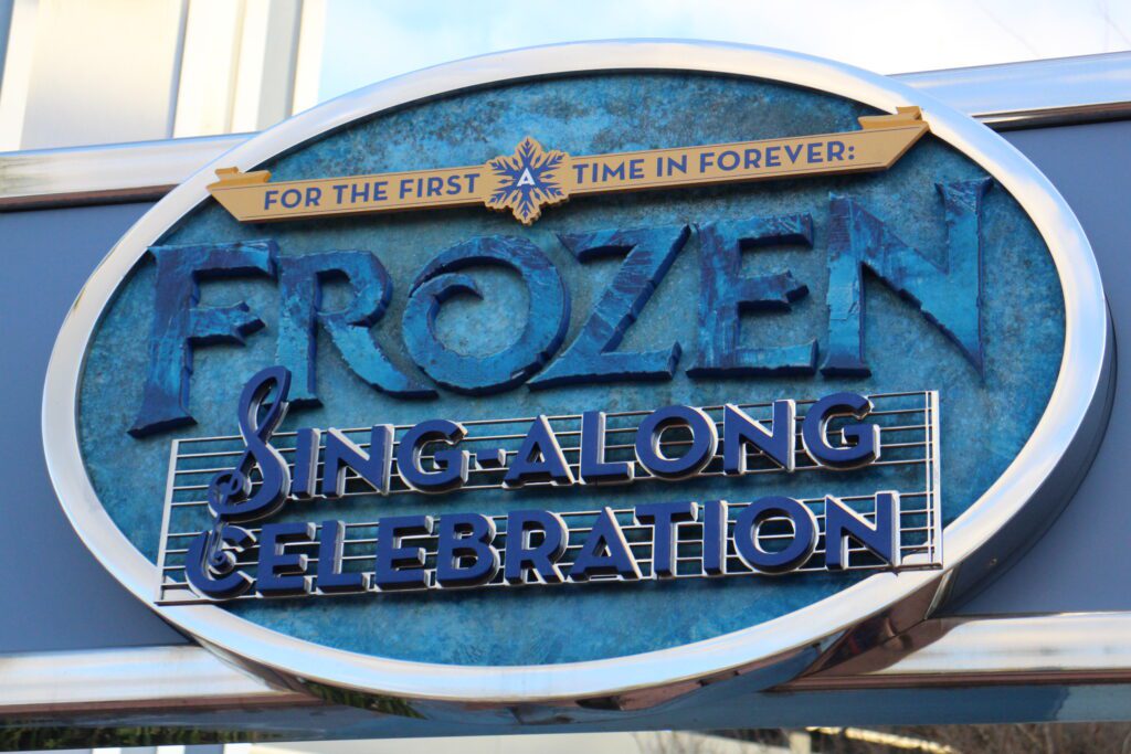 A blue, icy looking sign that says For the First Time in Forever Frozen Sing-Along Celebration.