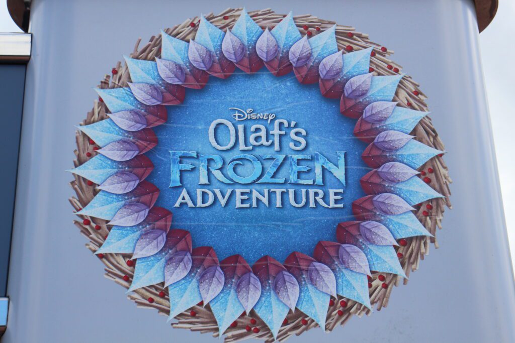 A sign outside the Frozen singalong that says Olaf's Frozen Adventure in icy blues and purple-y pinks.