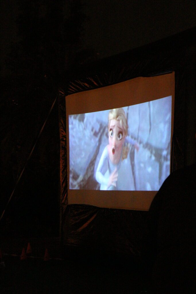 Elsa in Frozen 2 on an outdoor movie screen at Disney's Polynesian Village Resort.