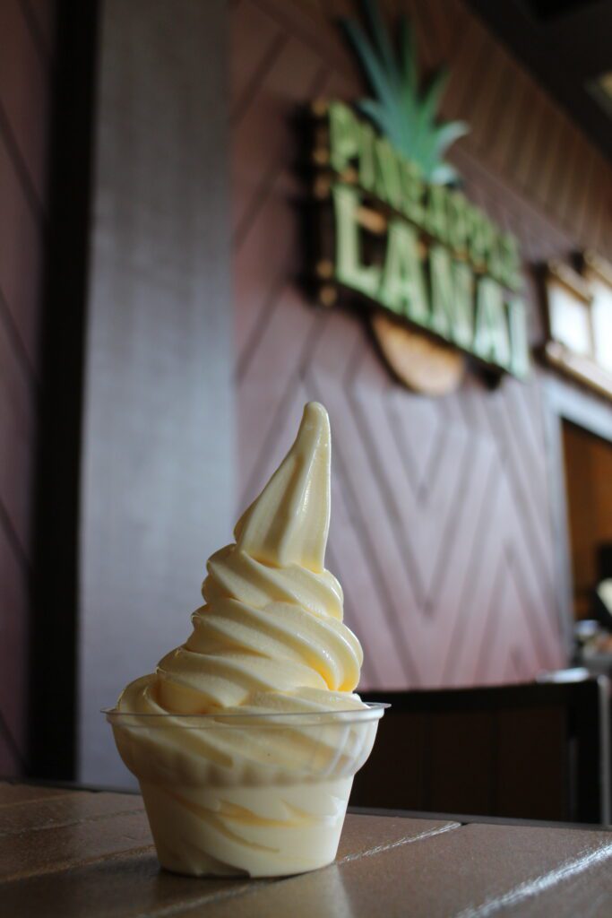 At Pineapple Lanai, one of the Polynesian restaurants, a swirly dole whip soft serve sits in a clear plastic cup. 