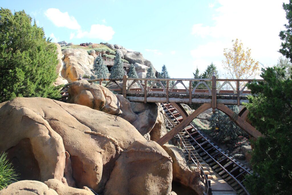 Seven Dwarfs Mine Train rocks, track and trees surround a little mountain.