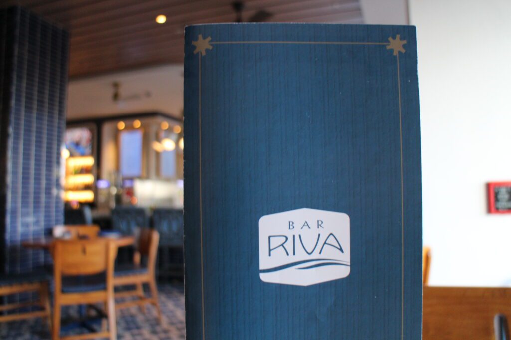 A Bar Riva menu with the restaurant out of focus behind it.