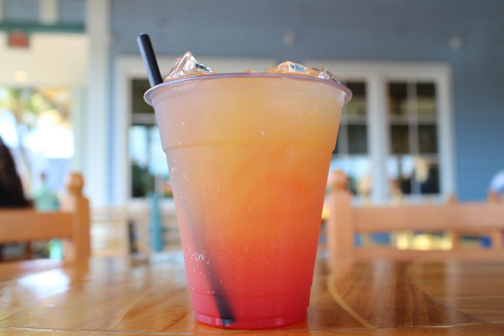 An orange gradient drink in a clear cup on a table.