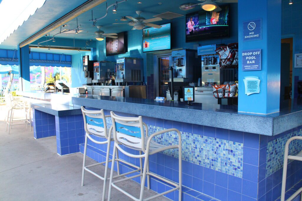 The Drop Off pool bar at Disney's Art of Animation Resort, covered in blue tiles with lots of other blue and a few seats in front of it.