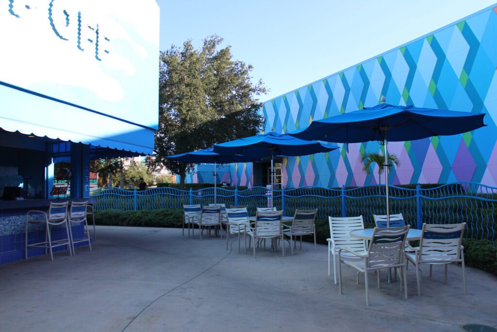 Chairs and tables under umbrellas at The Drop Off pool bar.