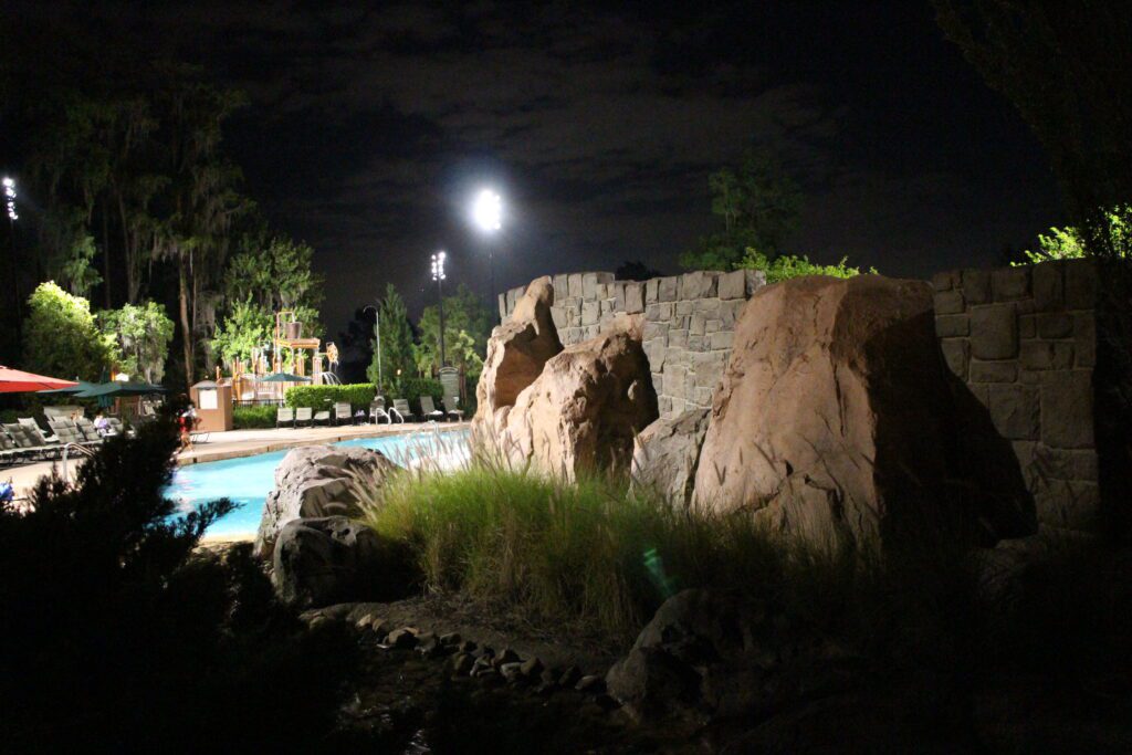 Wilderness Lodge pool at night with rocks surrounding it.