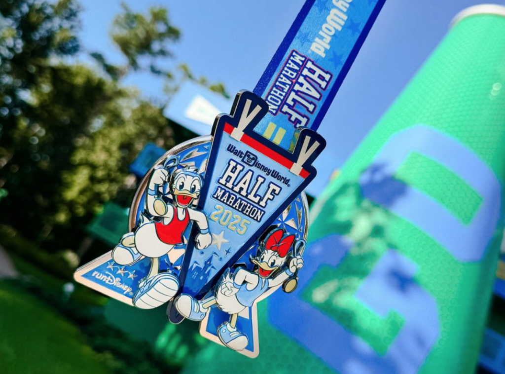 The Disney World Half Marathon 2025 medal with Daisy and Donald in front of a Spaceship Earth design.