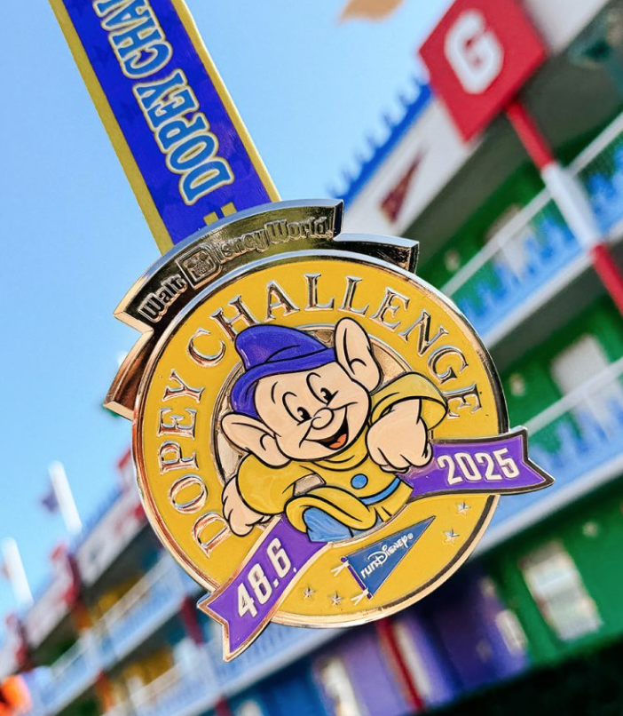 The 2025 Dopey Challenge medal with the character running toward you in the middle of a gold emblem.