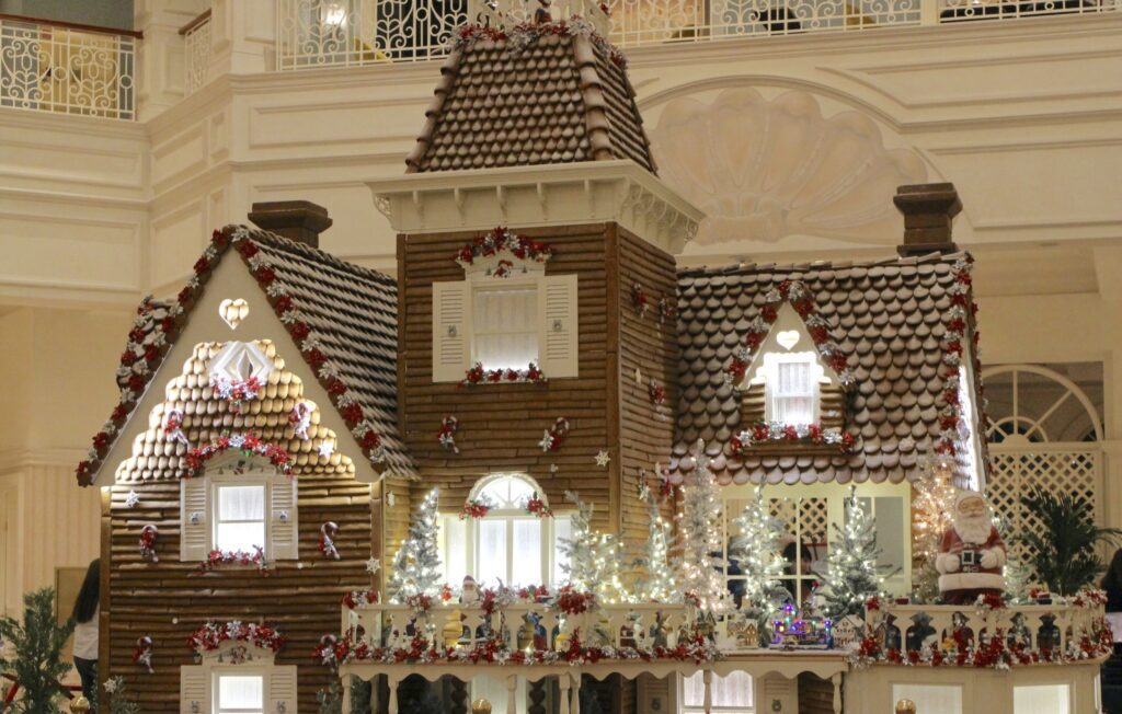 Gingerbread house at the Grand Floridian with poinsettias lining the roof.