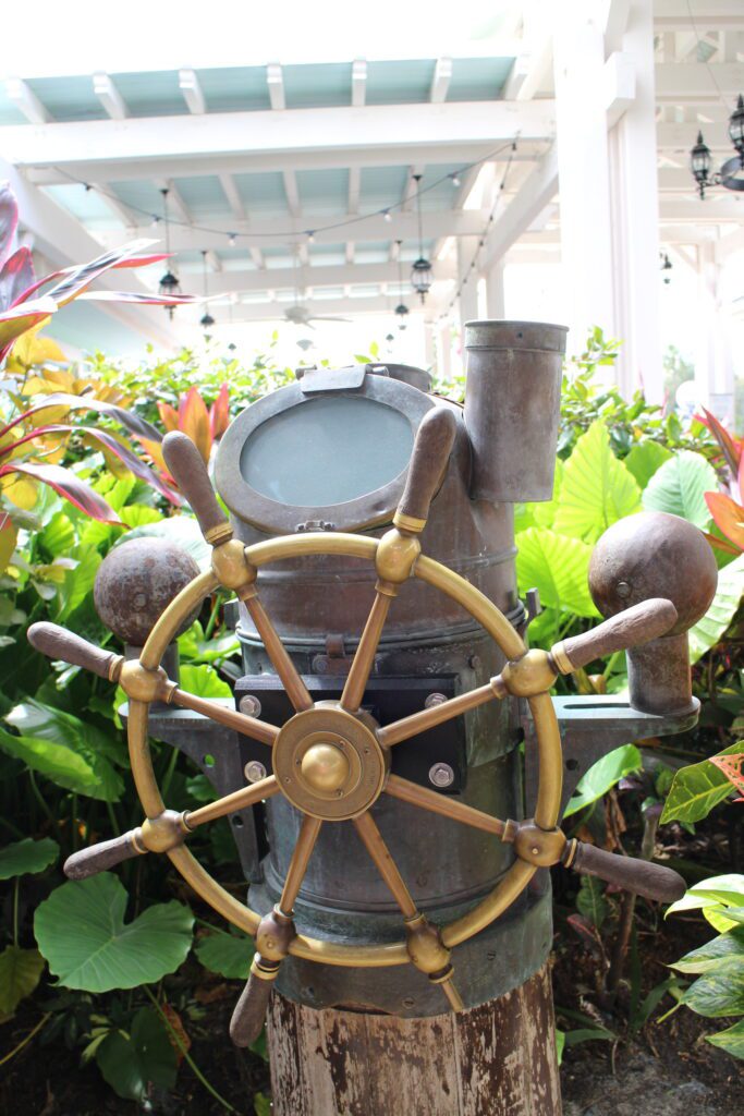 A ship wheel surrounded by tropical landscaping at Disney's Old Key West Resort.