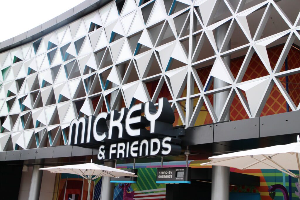 An artsy building says Mickey & Friends and has a standby entrance wait time posted at 25 minutes.