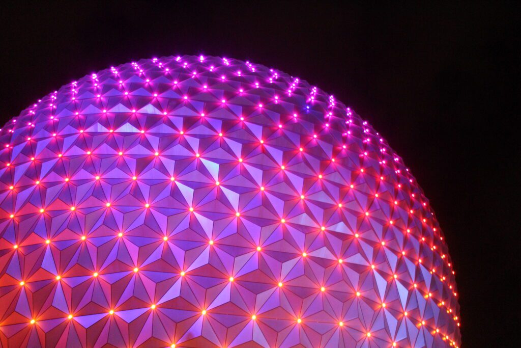 Spaceship Earth lit up pink at night.